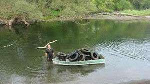 A volunteer cleans up scrap tires in the Winooski River last Saturday