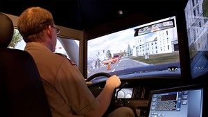 An officer behind the wheel of an L3-MPRI driving simulator.