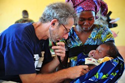 Pediatrician Barry Finette examines a child at a clinic in Togo. - FILE PHOTO COURTESY OF DR. BARRY FINETTE