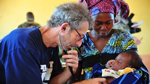 Pediatrician Barry Finette examines a child at a clinic in Togo.