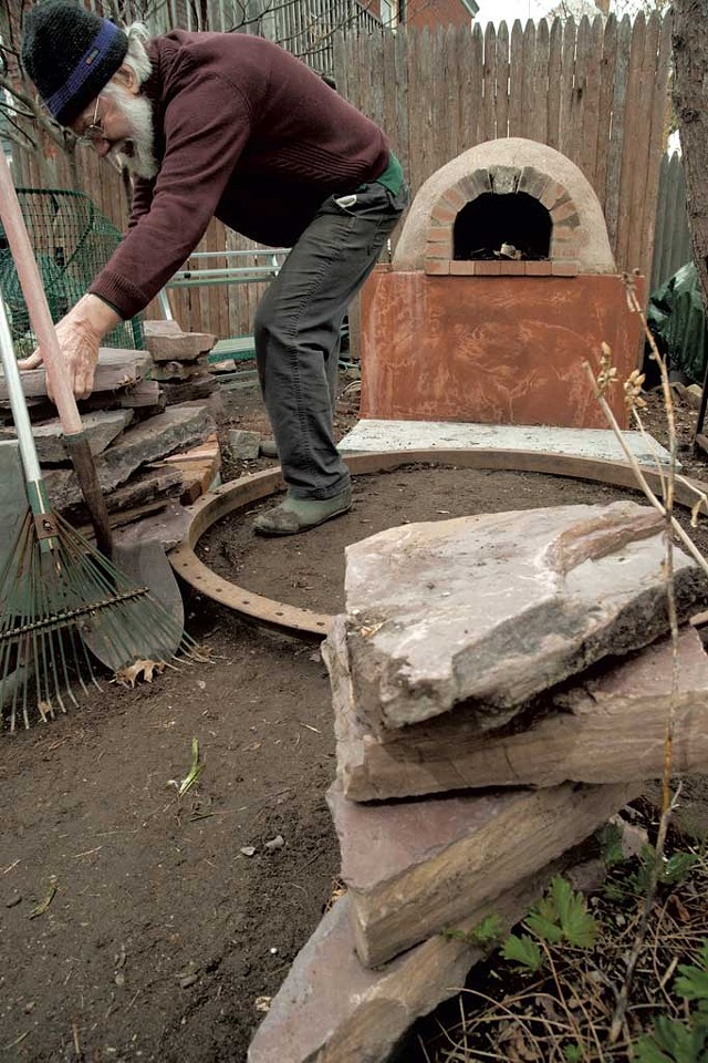 Charlie McClintock finishes the hardscaping around the pizza oven constructed last fall. - MATTHEW THORSEN