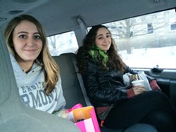 Christina Hart, left, and Zoe Gagnon, right, share a taxi ride from their jobs at the University Mall home to downtown Burlington Monday evening. - ALICIA FREESE