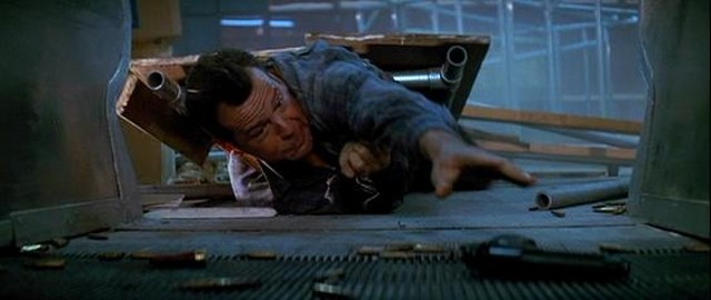 John McClane reaches for his gun in the film's cleverest sequence. - 20TH CENTURY FOX PICTURES