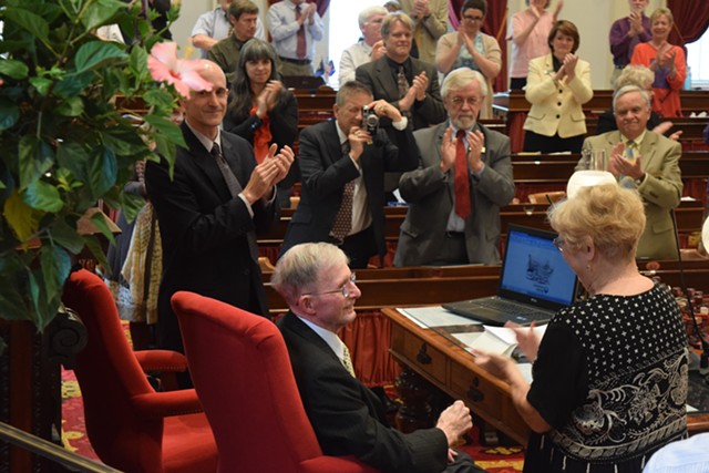 Rep. Joanna Cole (D-Burlington), right,  congratulates House clerk Don Milne (seated) Saturday after Milne's pending retirement was announced. To his left is Bill Magill, who was elected to replace Milne. - TERRI HALLENBECK