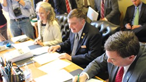 Rep. Patrick Brennan (R-Colchester) signs off on legislation banning the use of cellphones while driving.