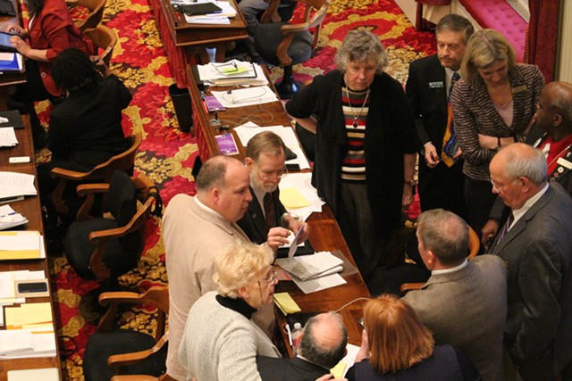 The House Education Committee huddles on the House floor Wednesday. - PAUL HEINTZ