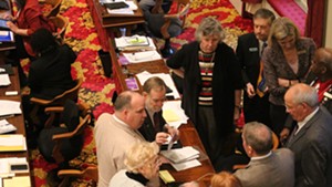 The House Education Committee huddles on the House floor Wednesday.