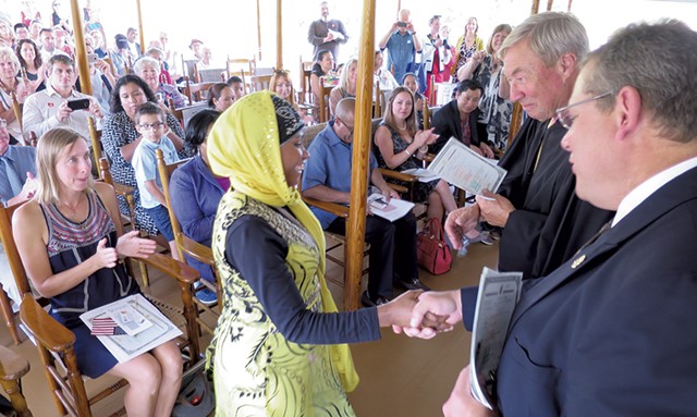 Judge Sessions congratulates a newly naturalized American aboard the Ticonderoga steamboat at Shelburne Museum this September. - MATTHEW THORSEN