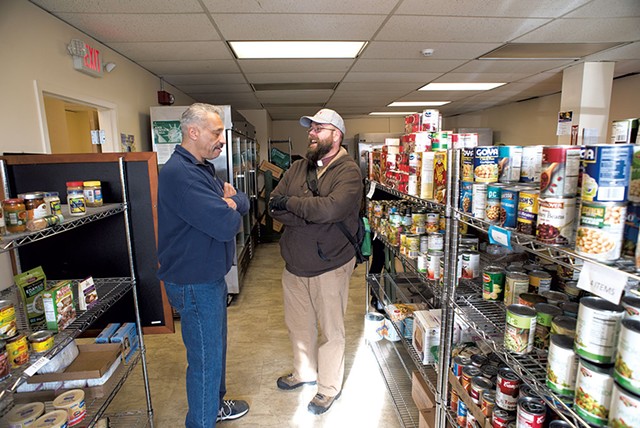 Rev. John Longworth (right) talking with Rodney Palmer at the BROC Community Action in Southwestern Vermont Food Shelf - CALEB KENNA