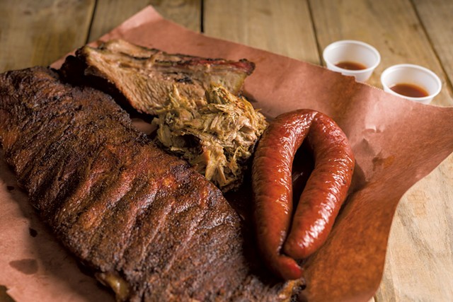 Smorgasbord of smoked meats: ribs, brisket, pulled pork and sausage - OLIVER PARINI