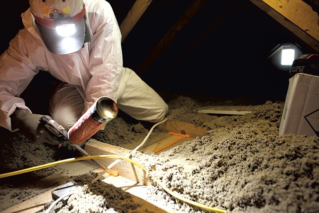Brian Hyde of Energy Co-op of Vermont, sealing gaps in a Colchester attic - KEVIN MCCALLUM