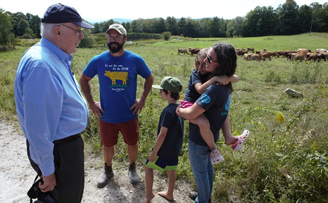 Leahy chats with the Webbs near their herd. - KEVIN MCCALLUM