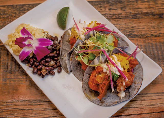 Buffalo cauliflower tacos with turmeric slaw and blue cheese crema, served with brown jasmine rice and Cuban black beans - GLENN RUSSELL