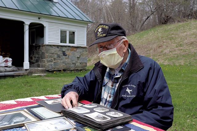 James J. Hasson, 94, flipping through World War II photos at his Cavendish home - DEREK BROUWER