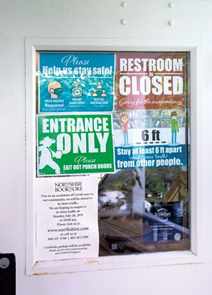 Northshire Bookstore door showing COVID-19 precautions and temporary closure due to suspected cases - CHRISTINE GLADE