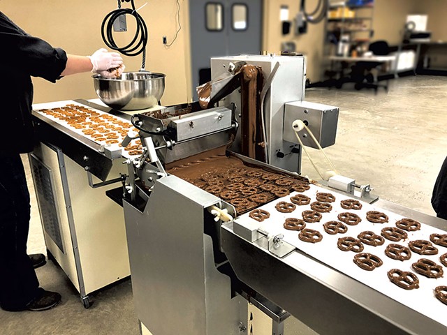Enrobing machine coating pretzels with chocolate at Vermont Nut Free Chocolates - COURTESY OF VERMONT NUT FREE CHOCOLATES
