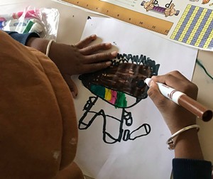 A student at JFK Elementary drawing a masked self-portrait - COURTESY OF THE WINOOSKI SCHOOL DISTRICT