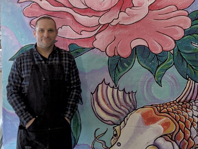 Brian Lewis in front of a mural by Tara Goreau at Filling Station - COURTESY OF BRIAN LEWIS