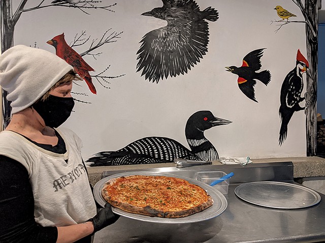 Hailey Cohn of Woodbelly Pizza in front of a mural by Frances Cannon - COURTESY OF KES MARCEL