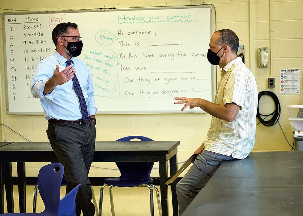 Tom Flanagan (left) talking with science teacher Nathan Caswell during a tour of Hunt Middle School - BEAR CIERI