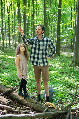 Ari Rockland-Miller showing an example of a nonedible mushroom while his daughter Eliana Rockland-DiMare, 7, looks on at Shelburne Farms - DARIA BISHOP