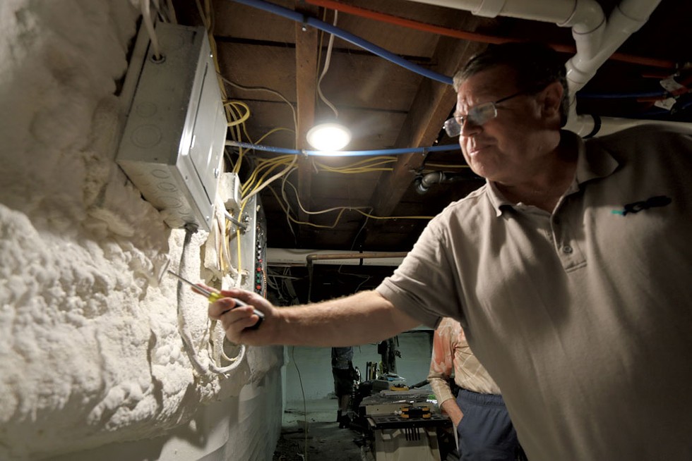 Vermont Gas energy auditor Wayne Thompson inspecting the foam insulation added to Swinton's basement - KEVIN MCCALLUM ©️ SEVEN DAYS