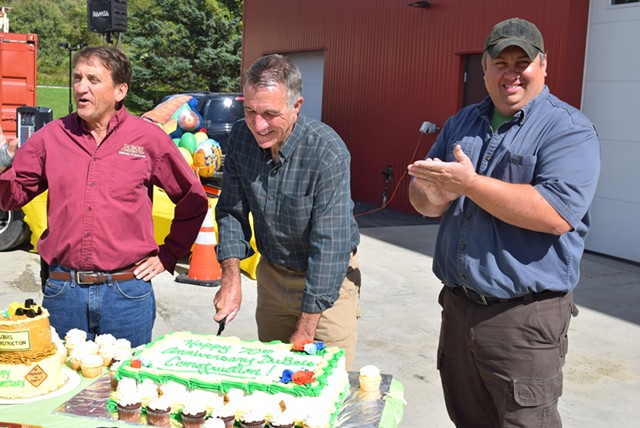 Republican gubernatorial candidate Phil Scott (center) cuts a cake commemorating DuBois Construction’s 70th anniversary, with co-owner Don DuBois (left) and new partner Jeff Newton Saturday. - TERRI HALLENBECK