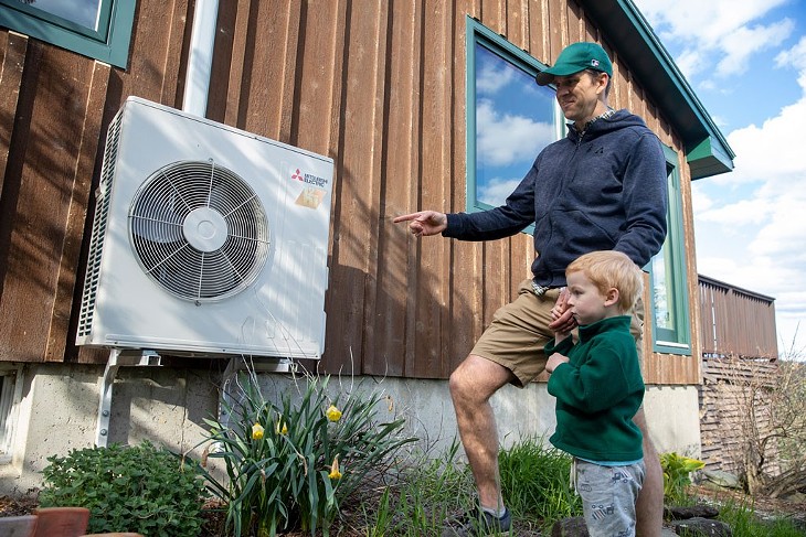 Mike shows off the heat pump to his son Roan - JAMES BUCK