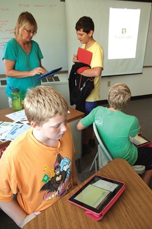 Hinesburg Community School health teacher Cindy Stanley helps students navigate lessons on the iPad.