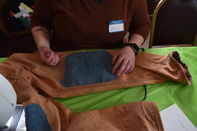 Christiana Bedard mending a pair of pants at the Clothing Repair Fair - SOPHIA AFSAR-KESHMIRI ©️ SEVEN DAYS