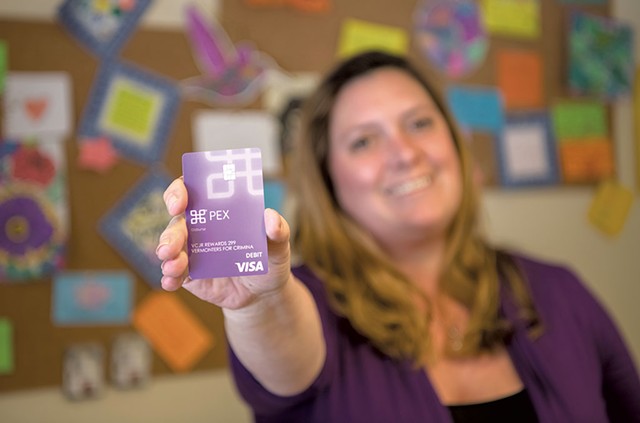 Jess Kirby holding a prepaid debit card at Vermonters for Criminal Justice Reform - DARIA BISHOP