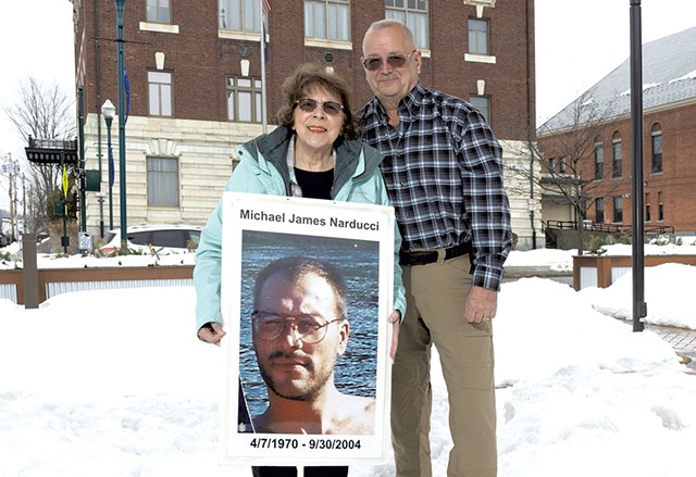 Betty and Chris Barrett holding a photo of their son, Michael, who killed himself in 2004 - DON WHIPPLE