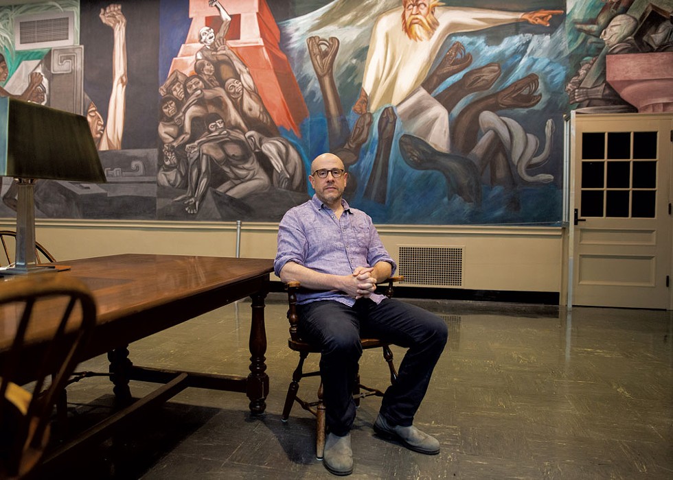 Jeff Sharlet in front of a mural by Mexican artist Jos&eacute; Clemente Orozco titled "The Epic of American Civilization" in Baker-Berry Library at Dartmouth College - ALEX DRIEHAUS