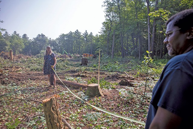 Lori Barg (left) and Jeff Conley measuring the distance from Conley's property line to the tree cutting - JAMES BUCK