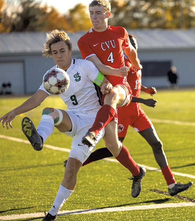 St. Johnsbury Academy's Gus Yerkes fending off Champlain Valley Union High School's Miles Bergeson in a state Division I quarterfinal match on October 28 - JAMES BUCK