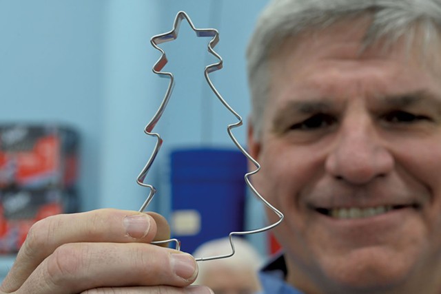 Ben Clark holding a Christmas tree cookie cutter at Ann Clark's Rutland manufacturing facility - JON OLENDER