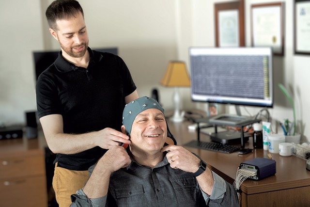 Dr. David Helfand (left) with a patient. The cap contains 19 electrodes that measure the brain's electrical activity. - COURTESY