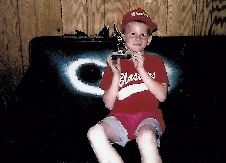 Michael at 10, holding his baseball trophy - COURTESY