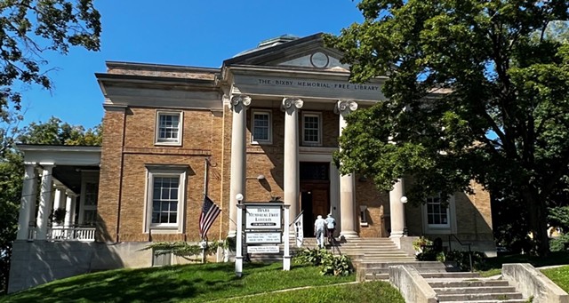 The Bixby Memorial Free Library, a brick building with large columns near the front entrance.