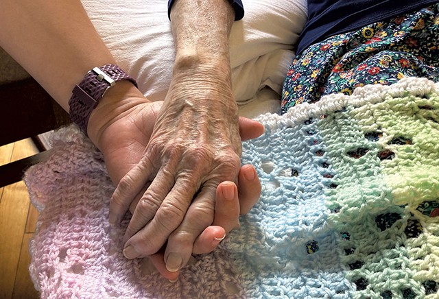 Mannebach holding hands with a family member as she dies - COURTESY OF THE FAMILY OF RITA MANNEBACH