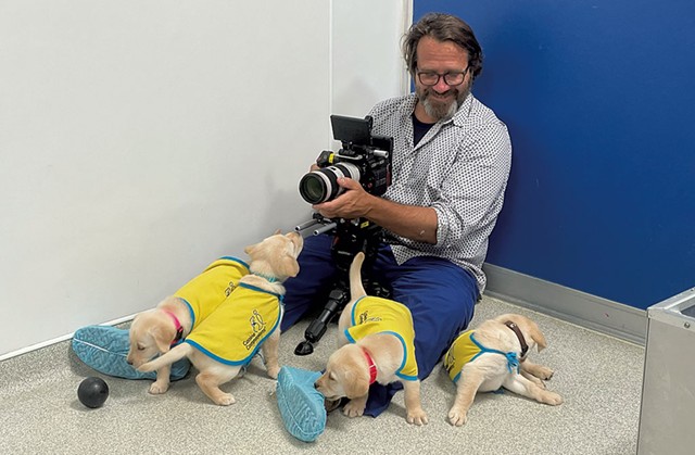 Directer Andy Mitchell getting footage of soon-to-be service dogs. - COURTESY OF KAILA LEE