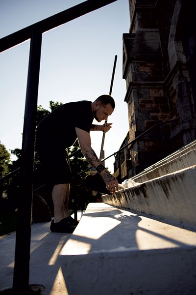 A man cleaning trash outside First United Methodist Church of Burlington - JAMES BUCK