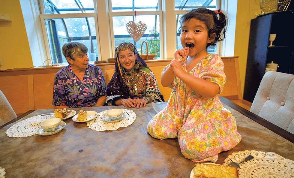 Linda Hay and Sohaila Nabizada watching Manahal Amiri enjoying some of Nabizada's leftover wedding cake - KRISTOPHER RADDER