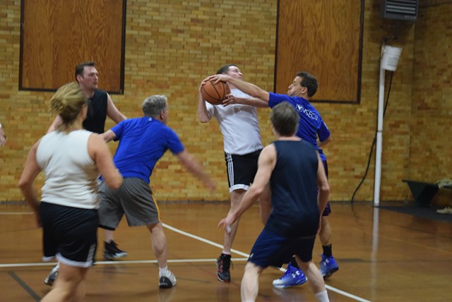Peter Sterling (in blue) blocks a shot by Matt McMahon (in white) during a legislative and staff basketball game Friday. - TERRI HALLENBECK