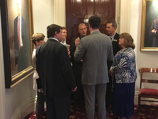 A group of Democratic lawmakers who supported Gov. Phil Scott’s proposal confer outside his office Wednesday afternoon. - TERRI HALLENBECK