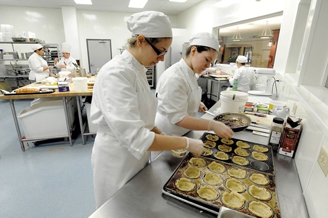 Rachel Kalinowski, left, and Lauren Layman fill savory mini quiches at NECI in Montpelier. - FILE: JEB WALLACE-BRODEUR