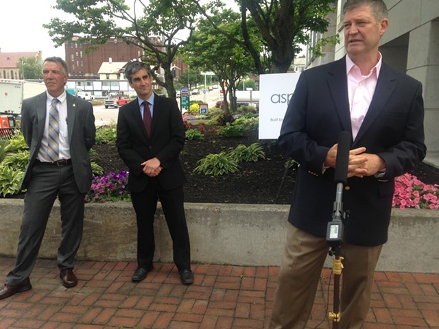 Chris Powell, CEO of Aspenti Health, speaks at Monday's press conference as Burlington Mayor Miro Weinberger (center) and Gov. Phil Scott (left) listen. - MOLLY WALSH/SEVEN DAYS