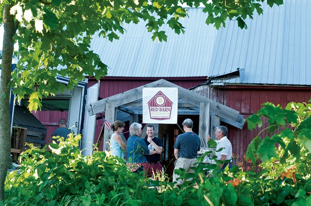 Peter McAlenney (center) talking with patrons at Red Barn Brewing - HANNAH PALMER EGAN