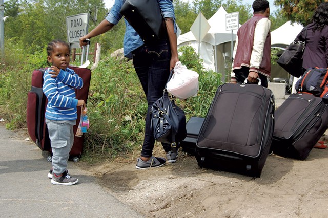Refugees wait to cross the Canadian border in Champlain, N.Y. - MARK DAVIS