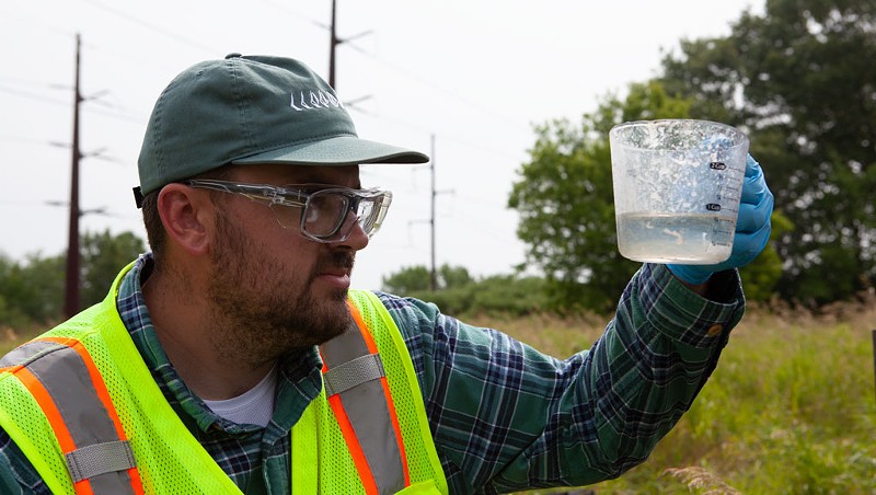 Aaron Sutton, an employee of an environmental firm, testing a well outside the Air National Guard base in South Burlington